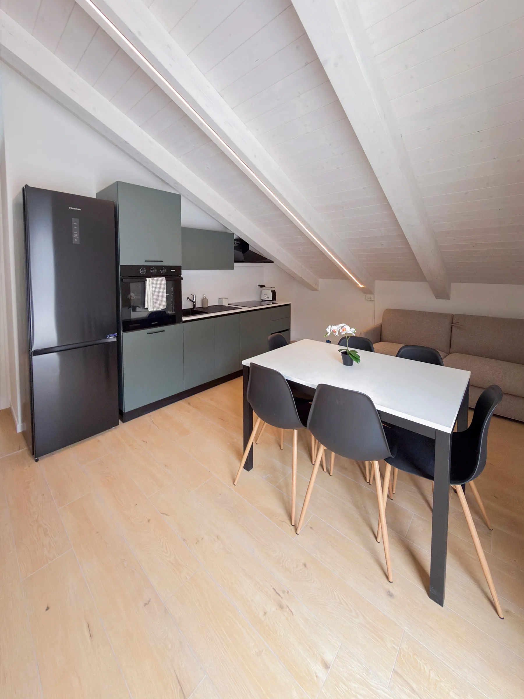 Suite Castello: kitchen with fridge and dining table under the sloped ceiling