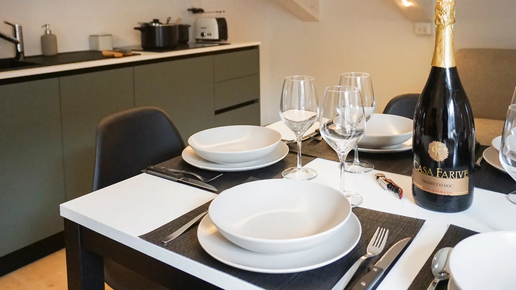 Suite Castello: table set with wine glasses and a bottle of sparkling wine, for a special evening