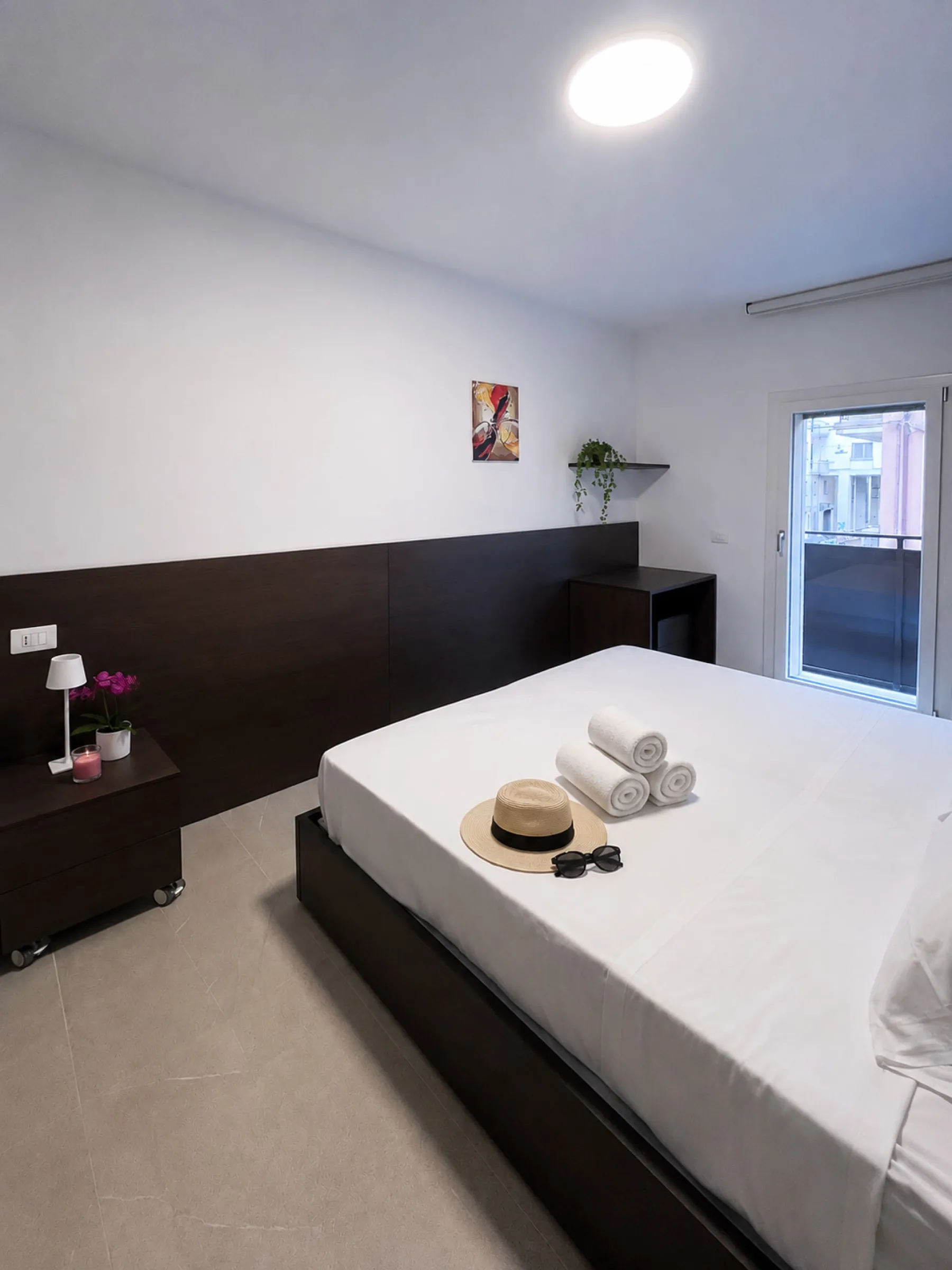 Suite Dorsoduro: bedroom detail with nightstand, lamp and bright window