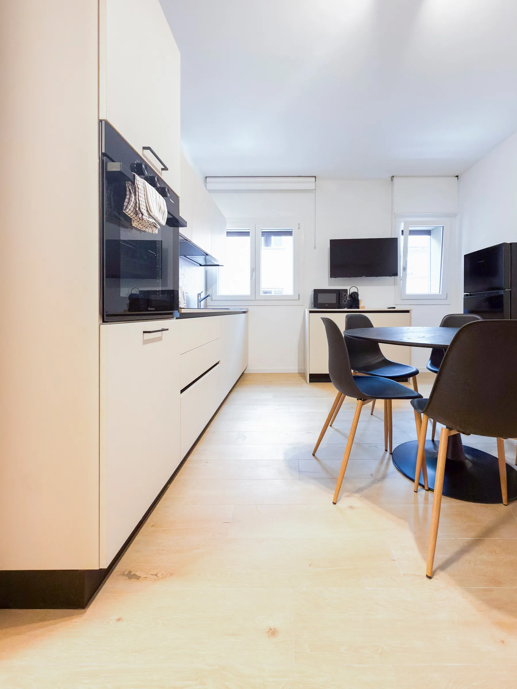 Suite Giudecca: kitchen with dining table and wall-mounted TV