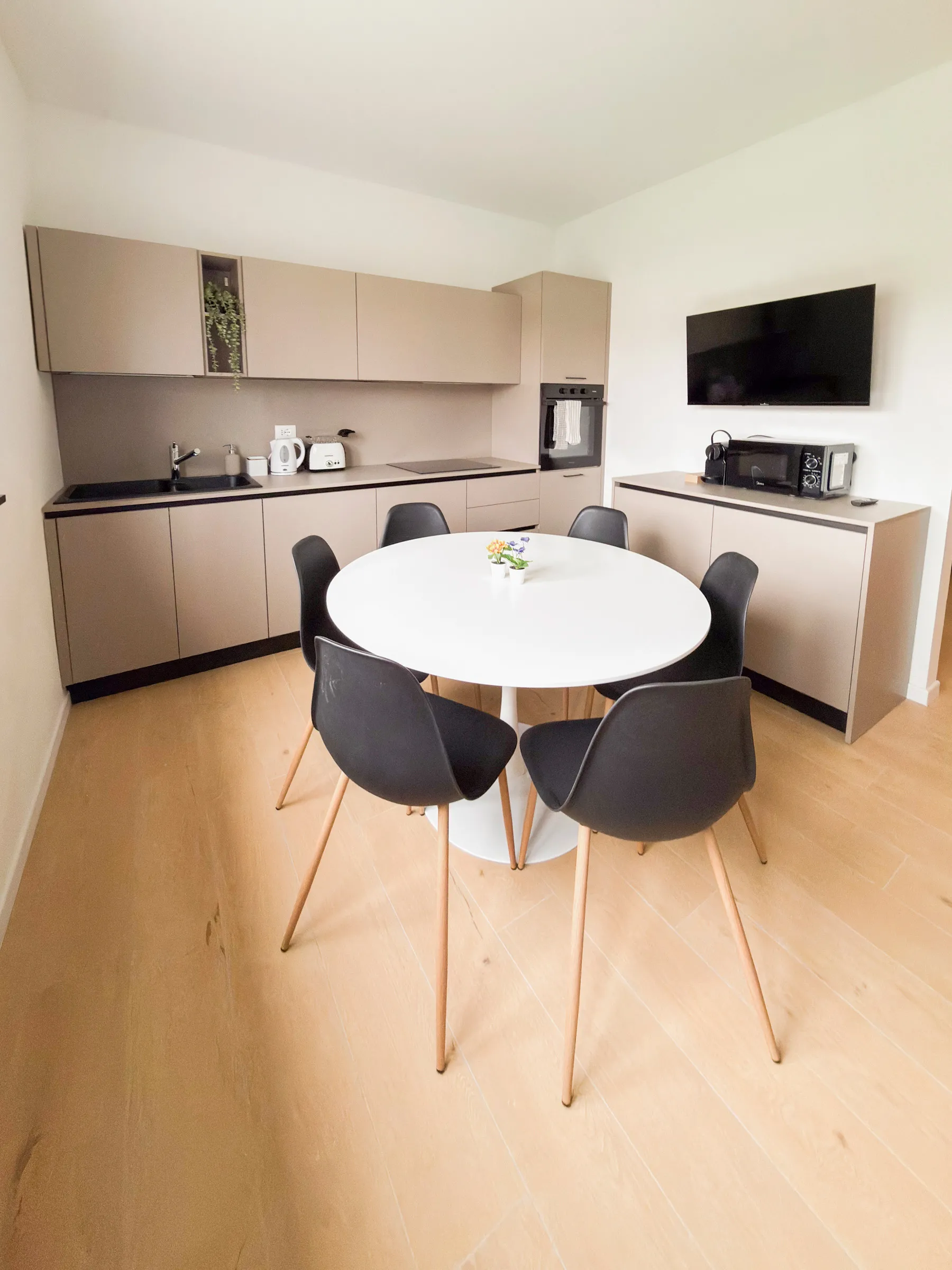 Suite San Marco: dining table with an orchid and the kitchen in the background